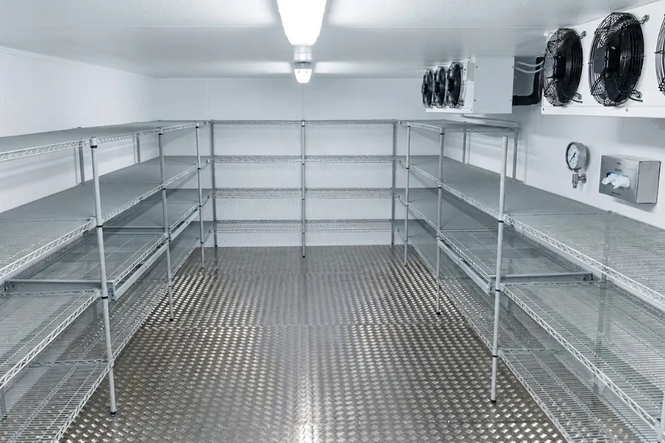 Walk-in cold room with stainless shelving and refrigeration equipment